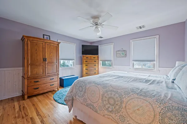 a spacious bedroom with a bed and a dresser