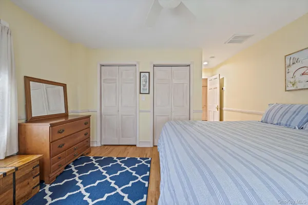 a spacious bedroom with a bed and a flat screen tv