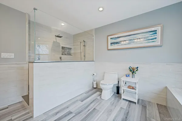 a spacious bathroom with a double vanity sink a mirror and a bathtub