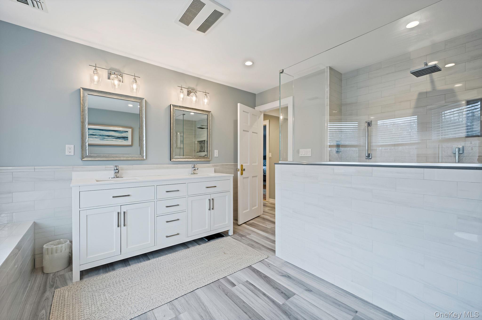 300 Private Road, Unit 8 Cutchogue, NY 11935 - Photo 41 of 47 a spacious bathroom with a double vanity sink a mirror and a bathtub