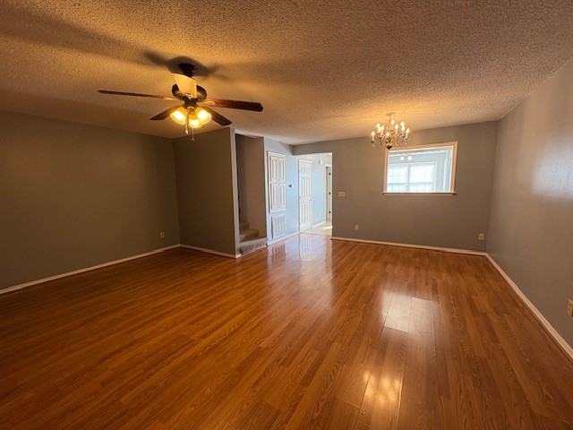 1800 Capps Road, Unit 9 Harrison, AR 72601 - Photo 1 of 18 Unfurnished room featuring wood finished floors, a chandelier, a textured ceiling, and ceiling fan