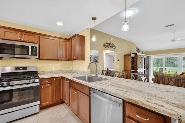 a kitchen with stainless steel appliances a stove sink microwave and cabinets