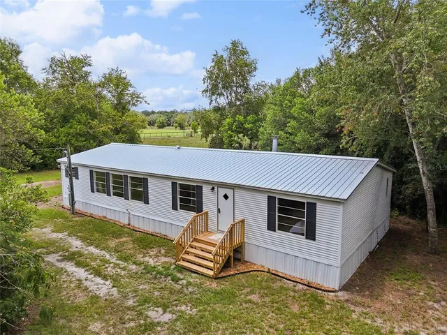 a view of a house with a yard and sitting area