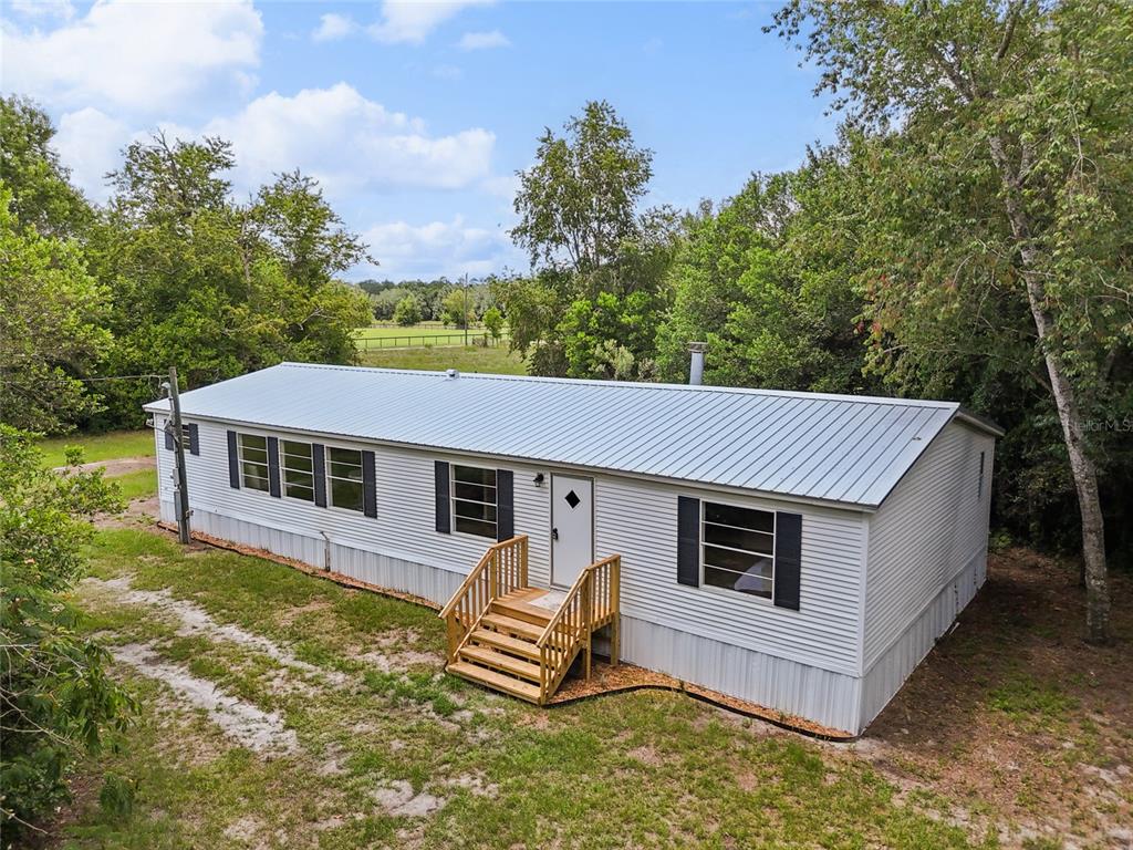 a view of a house with a yard and sitting area
