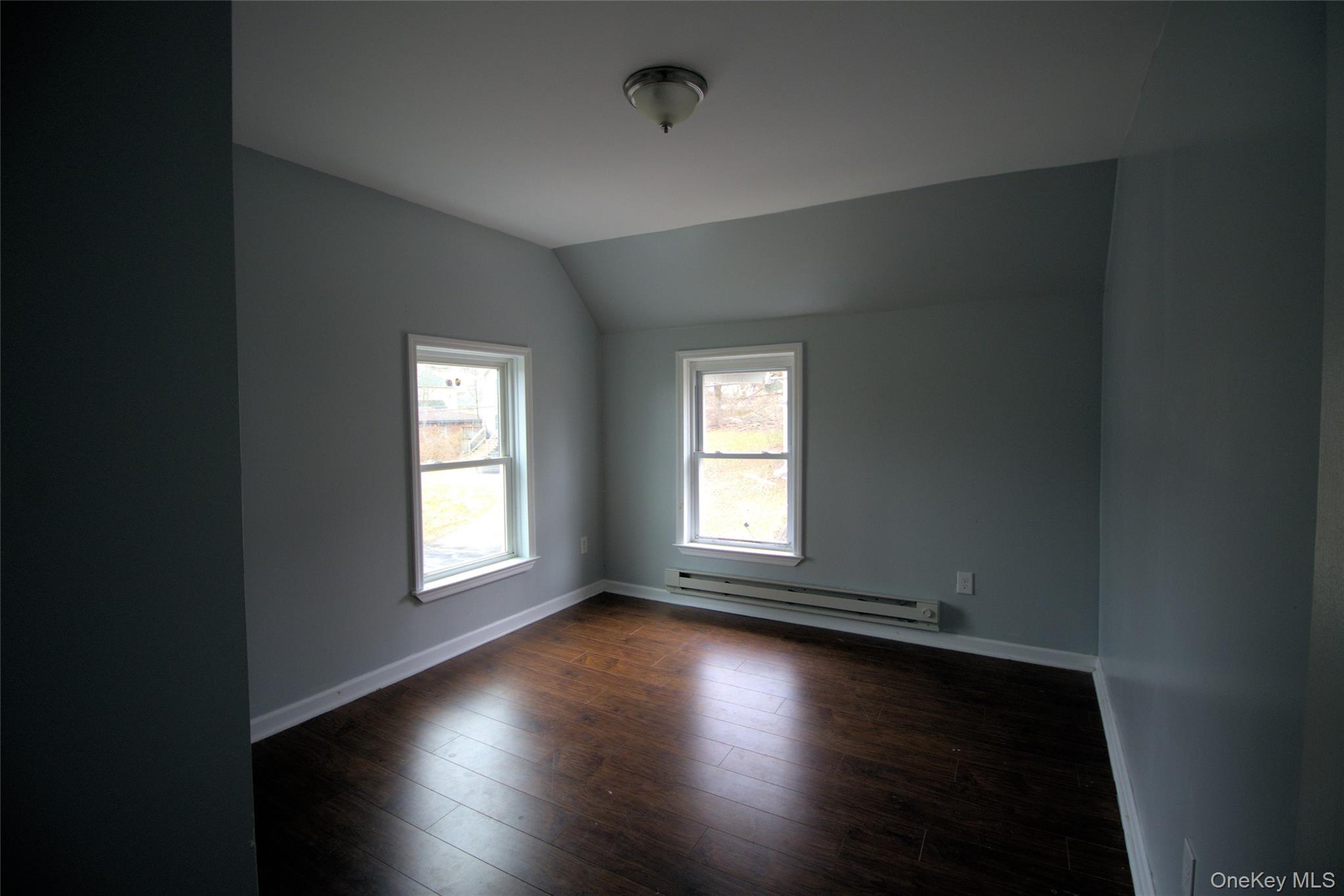 9 Spring Street Liberty, NY 12754 - Photo 23 of 29 Interior room featuring two double-hung windows, wood-finish flooring, and light gray wall paint