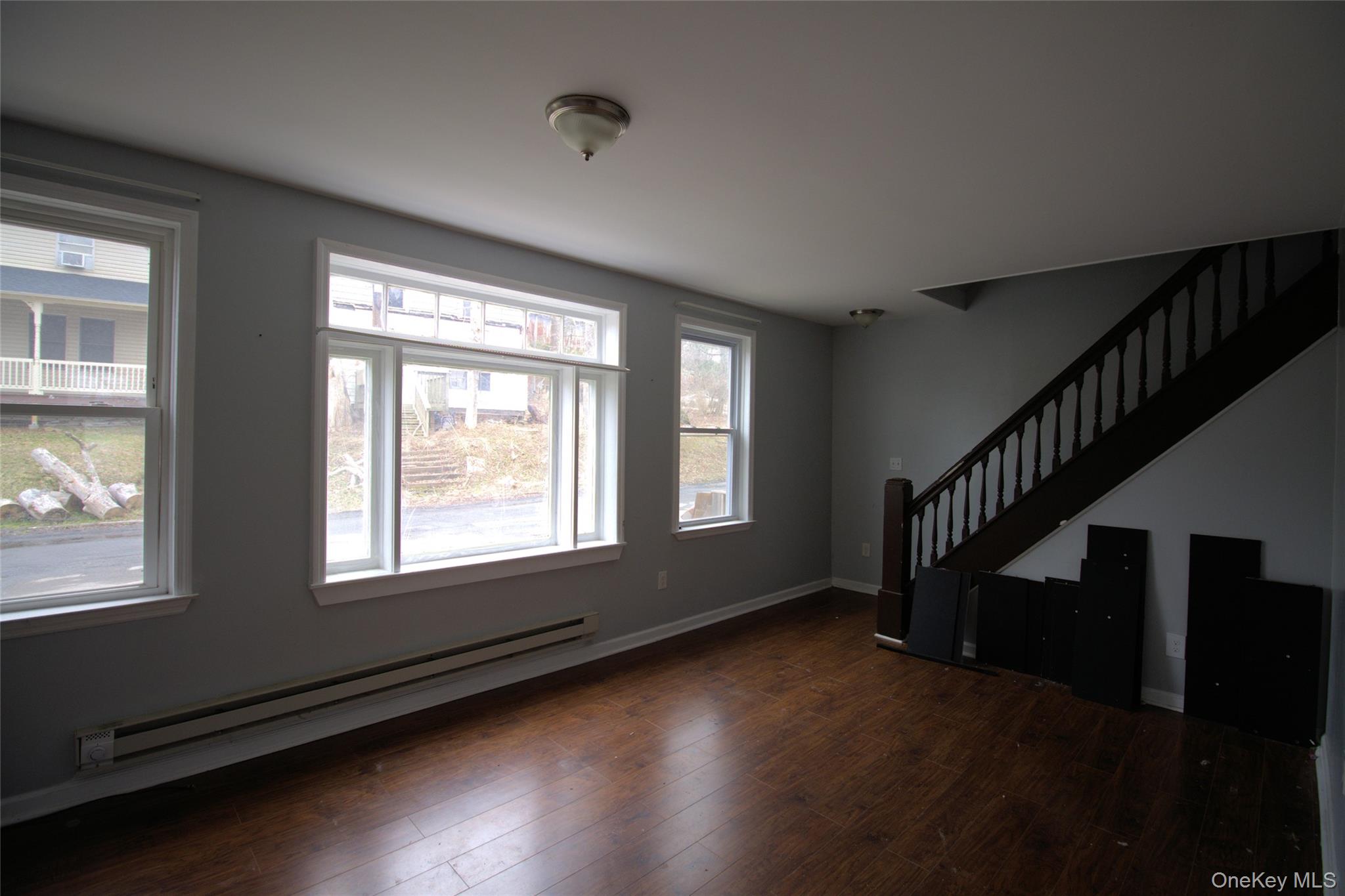 9 Spring Street Liberty, NY 12754 - Photo 28 of 29 Spacious room featuring wood-finish flooring and a prominent dark wood staircase