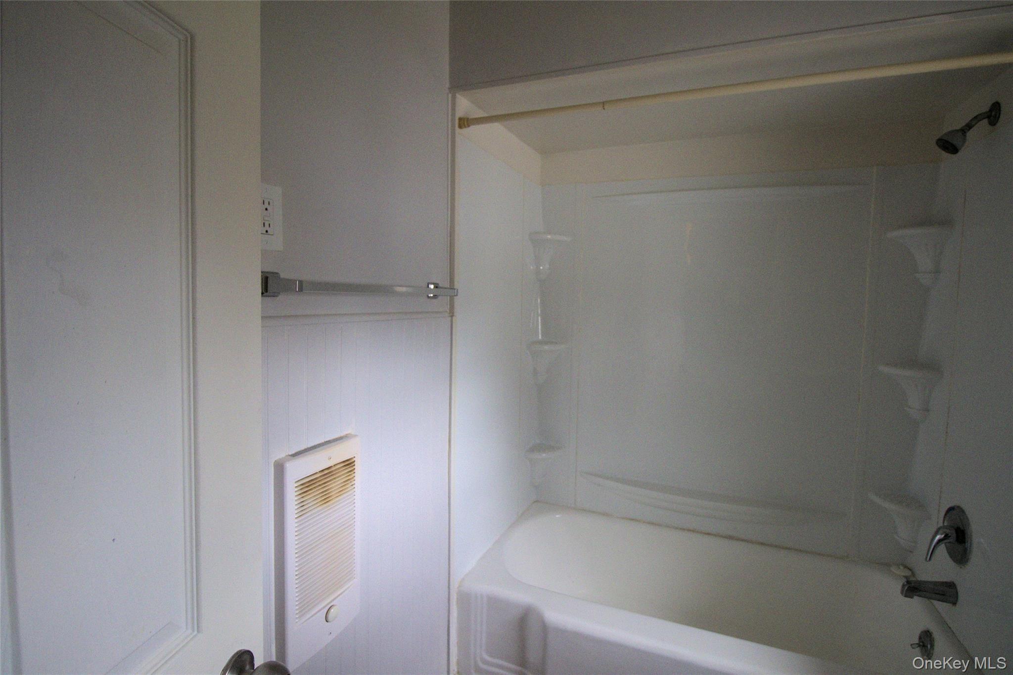 9 Spring Street Liberty, NY 12754 - Photo 8 of 29 White bathtub with integrated shower, equipped with a showerhead and faucet