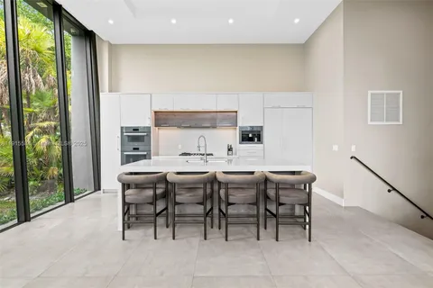 a dining room with furniture a rug and a floor to ceiling window