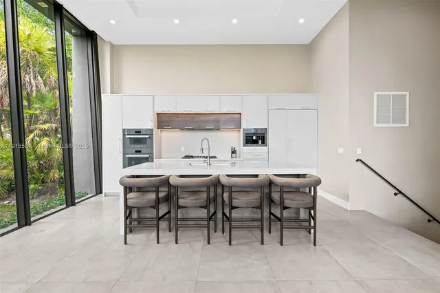 a dining room with furniture a rug and a floor to ceiling window