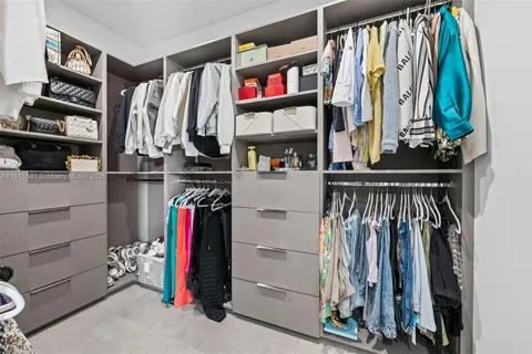 a view of walk in closet with clothes and shoes