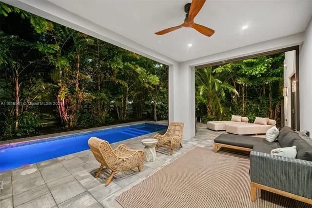 a living room with patio furniture and a floor to ceiling window