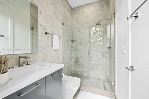 a bathroom with a sink shower and a mirror