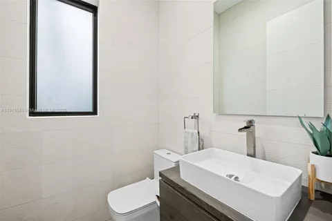 a bathroom with a sink a toilet and mirror