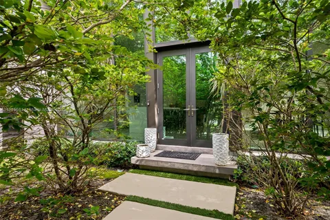a view of a house with a small yard and potted plants