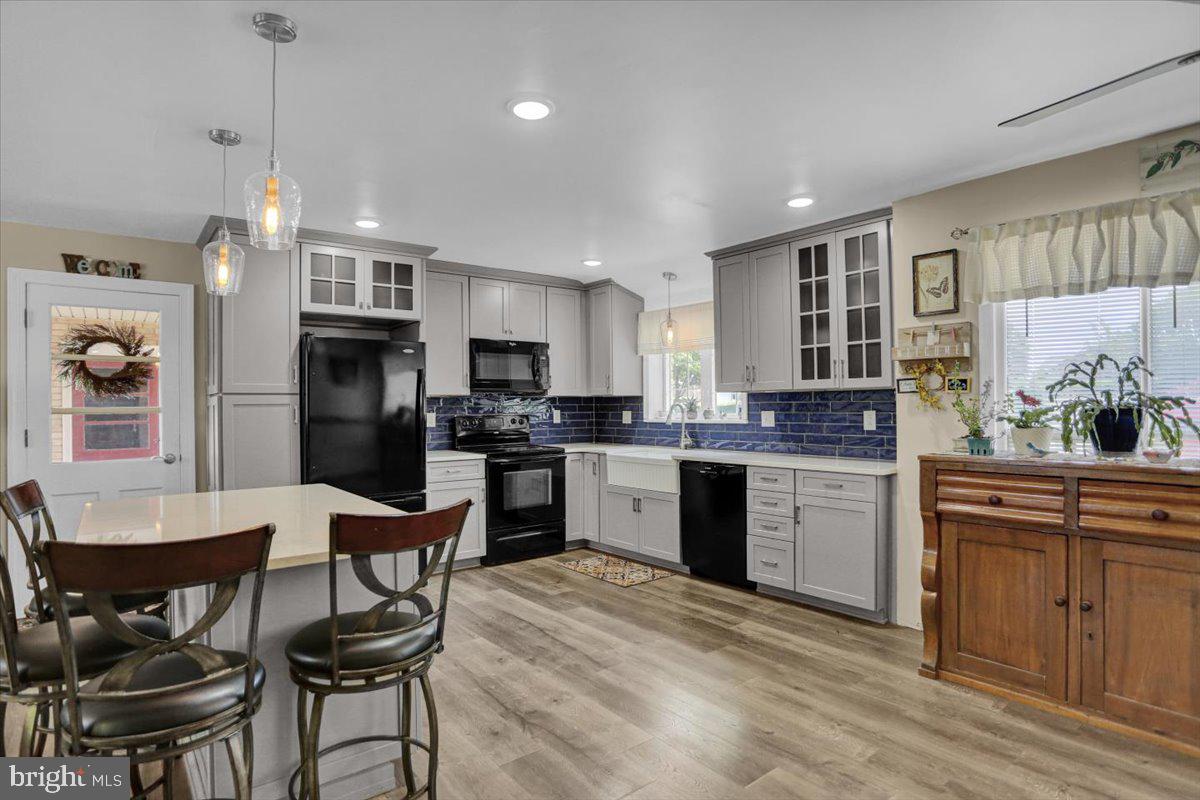 692 Brownsville Road Reading, PA 19608 - Photo 7 of 43 a kitchen with granite countertop a refrigerator a stove a sink dishwasher a dining table and chairs with wooden floor