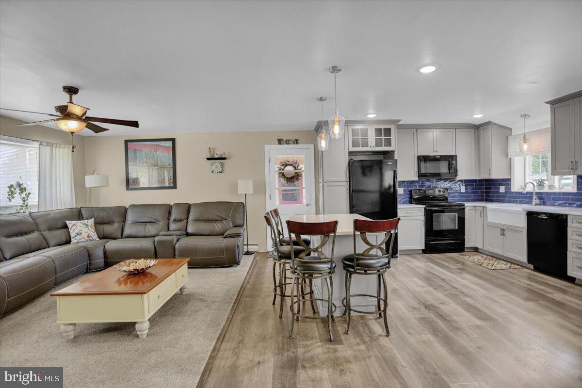 692 Brownsville Road Reading, PA 19608 - Photo 10 of 43 a living room with furniture kitchen area and a wooden floor