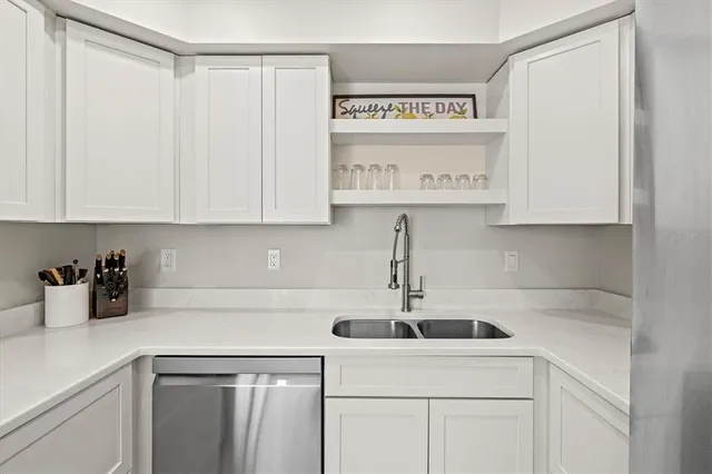 a kitchen with stainless steel appliances granite countertop a sink and a white cabinets