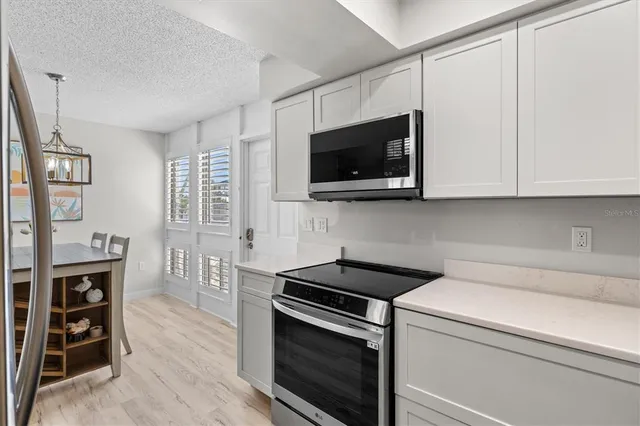 a kitchen with stainless steel appliances white cabinets and a stove top oven