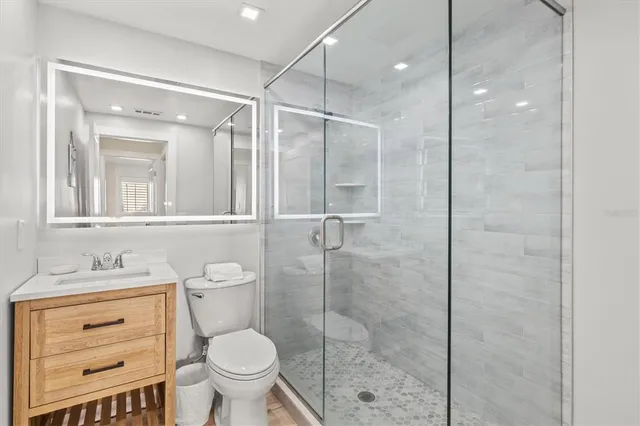 a bathroom with a granite countertop toilet sink and shower