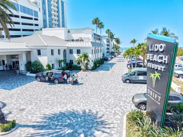 a view of a pool with lawn chairs and an ocean view