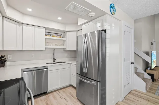 a kitchen with a refrigerator sink and cabinets
