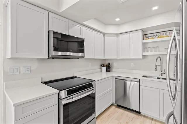 a kitchen with white cabinets stainless steel appliances and sink
