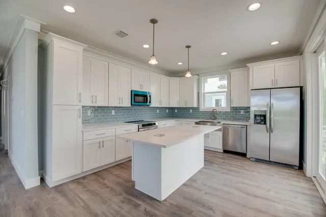 a kitchen with a refrigerator a sink and cabinets
