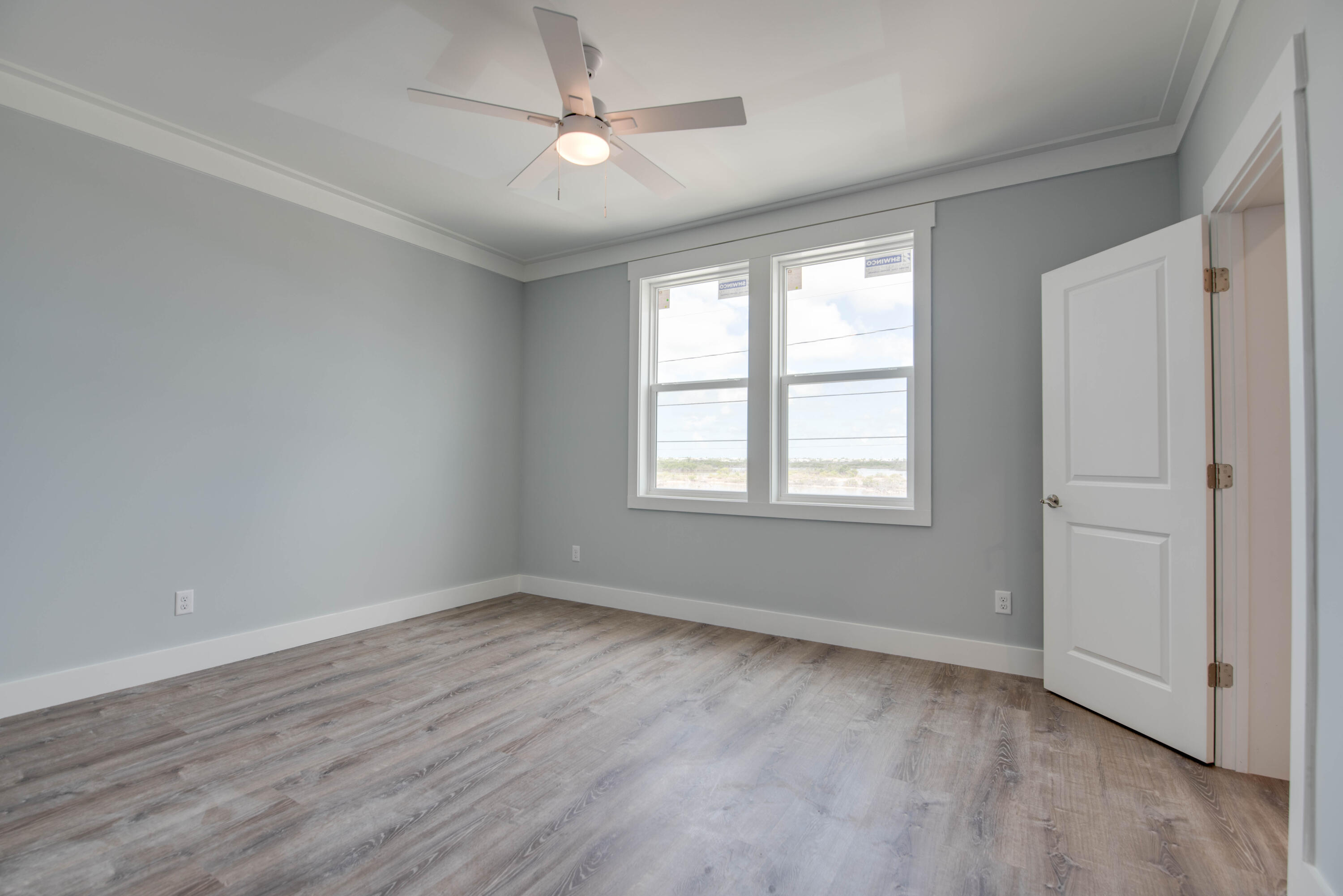 29558 Ranger Avenue Big Pine Key, FL 33043 - Photo 15 of 19 a view of an empty room with wooden floor and a window