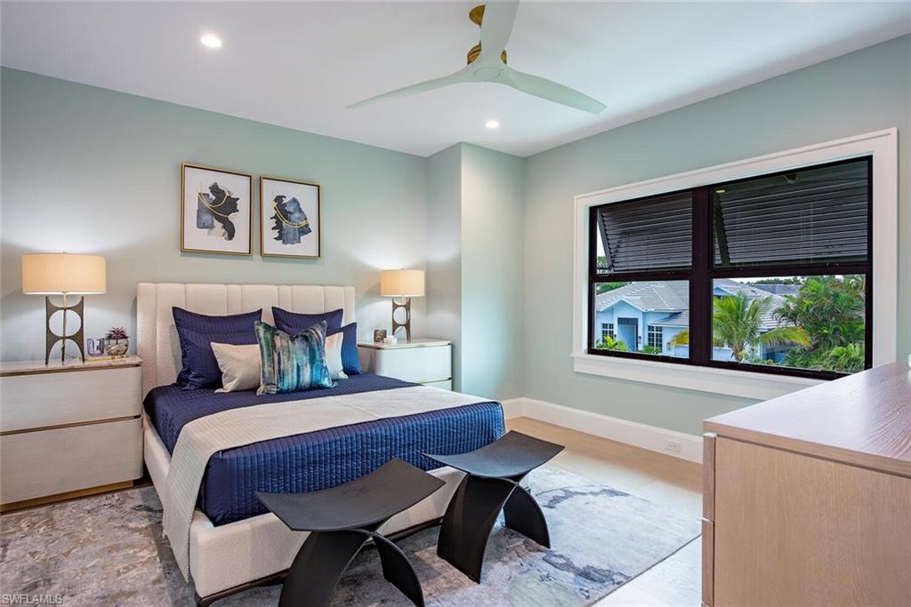 655 Parkview Lane Naples, FL 34103 - Photo 22 of 37 a bedroom with a bed two lamps and a large window