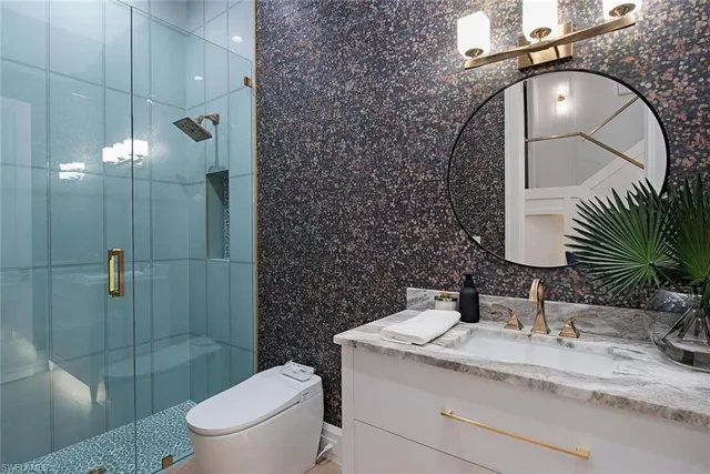 a bathroom with a granite countertop sink mirror toilet and shower