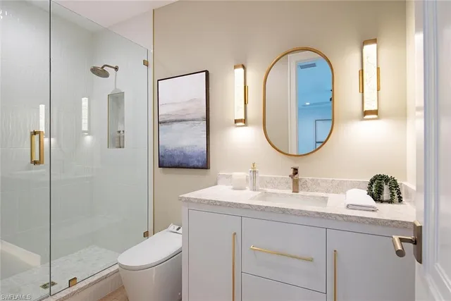 a bathroom with a granite countertop sink a toilet and a mirror