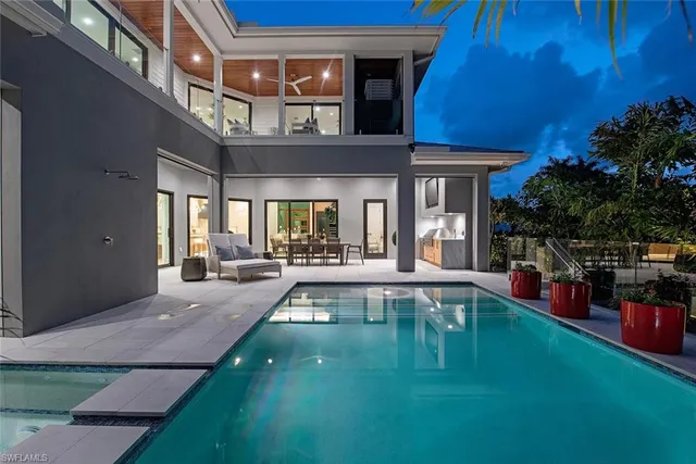 a view of a patio with couches table and chairs with potted plants and large tree