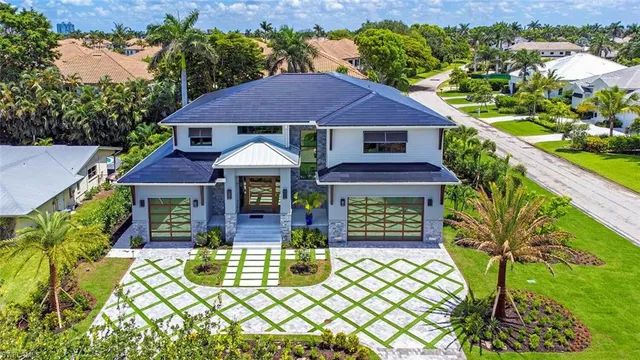 a front view of a house with a yard garden and outdoor seating