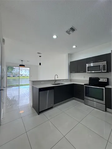 a large kitchen with stainless steel appliances a large counter top