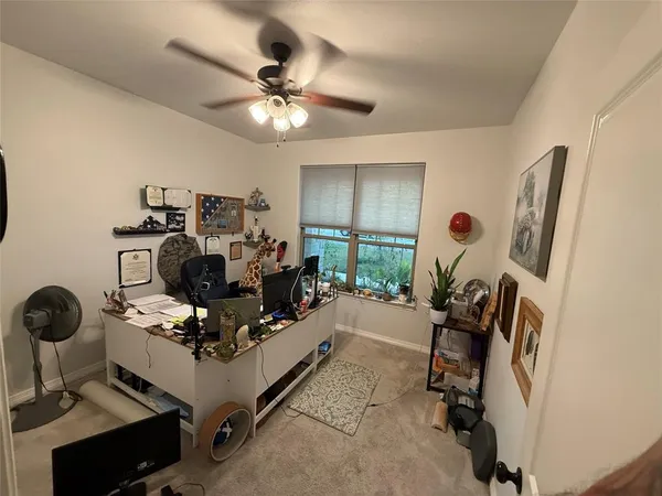 a view of a workspace with furniture and a window
