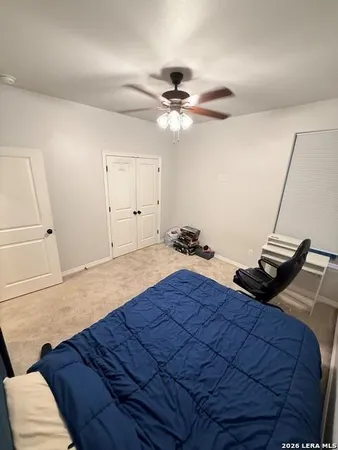 a bedroom with a bed and a ceiling fan