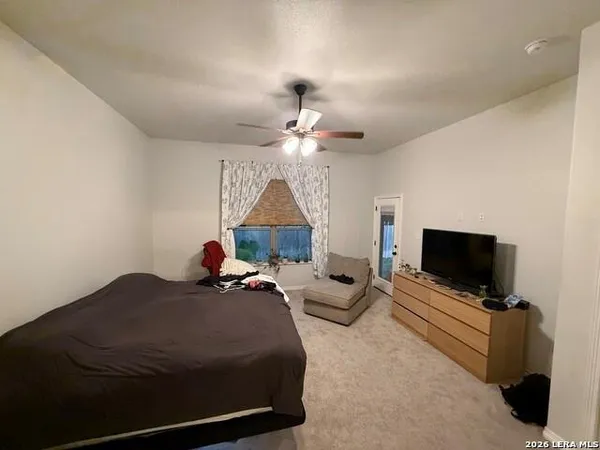 a bedroom with bed tv and window