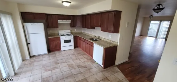 a kitchen with stainless steel appliances granite countertop a refrigerator and a stove