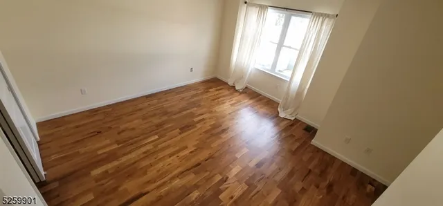 a view of a room with wooden floor and window
