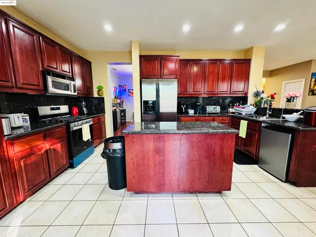 a kitchen with stainless steel appliances kitchen island granite countertop a stove a sink and a microwave