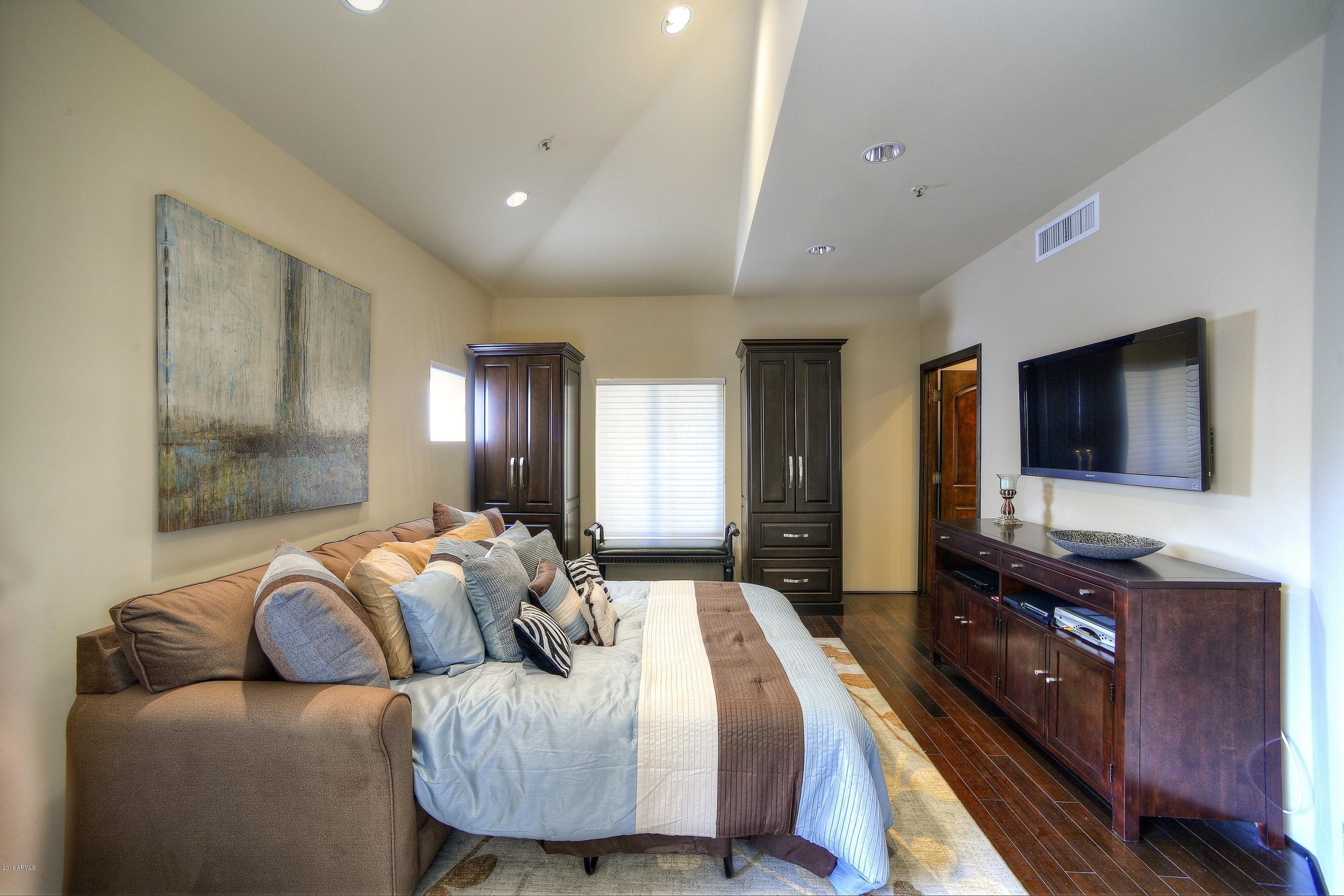 7740 East Gainey Ranch Road, Unit 58 Scottsdale, AZ 85258 - Photo 16 of 27 a bedroom with furniture and a flat screen tv
