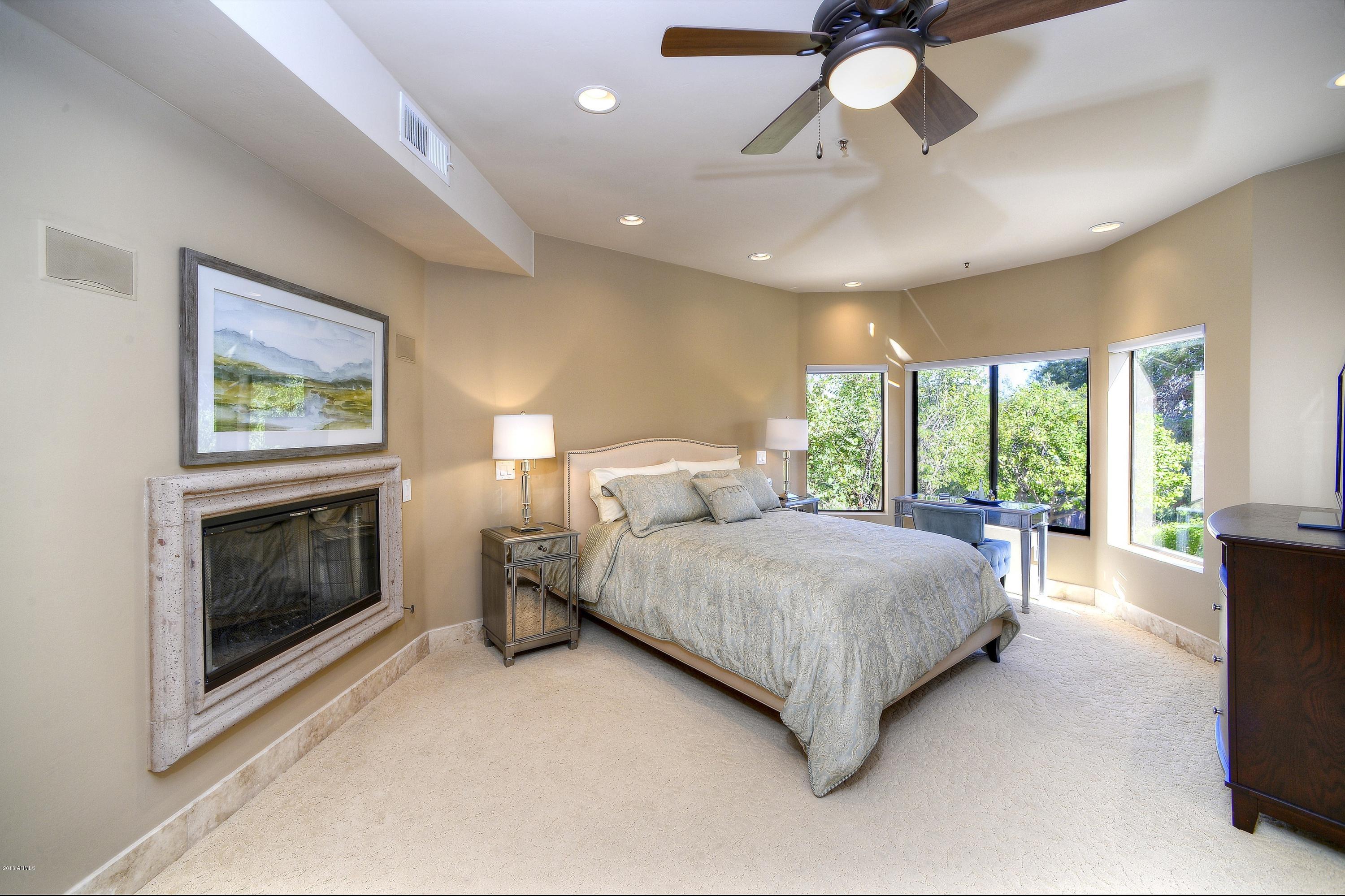 7740 East Gainey Ranch Road, Unit 58 Scottsdale, AZ 85258 - Photo 6 of 27 a spacious bedroom with a large bed and a chandelier fan