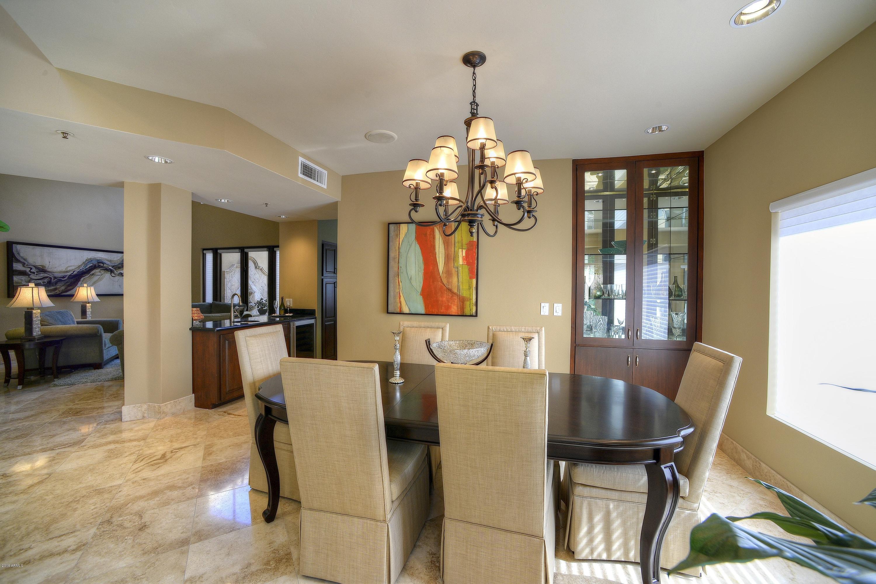 7740 East Gainey Ranch Road, Unit 58 Scottsdale, AZ 85258 - Photo 10 of 27 a view of a dining room with furniture and chandelier
