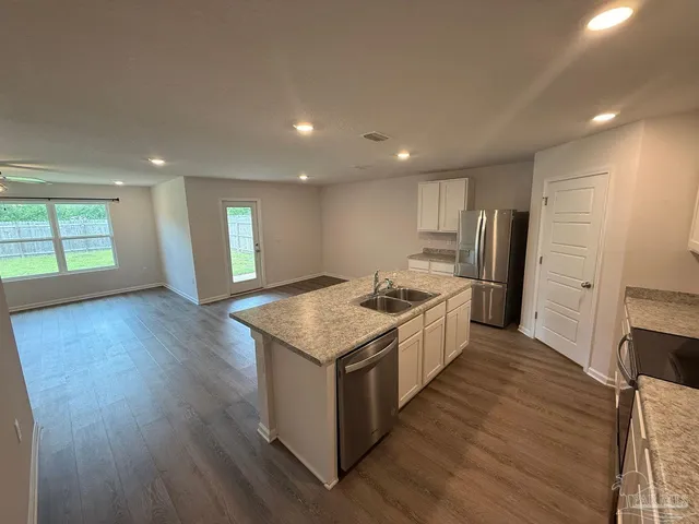 a kitchen with granite countertop a sink and a stove top oven