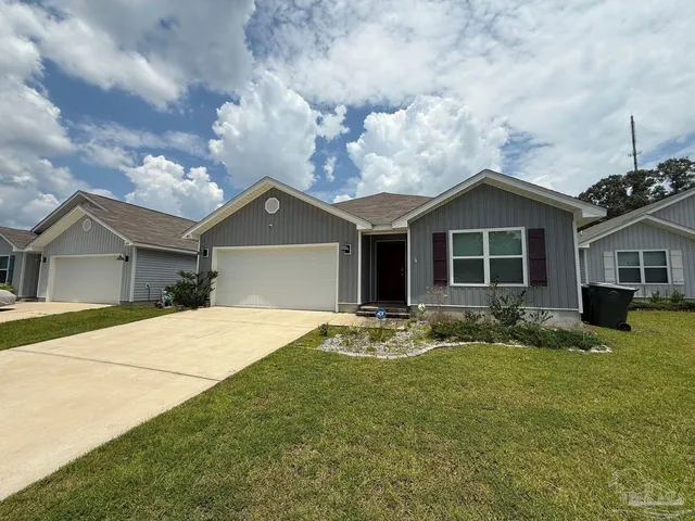 a front view of a house with yard and green space