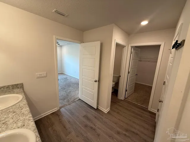 an empty room with wooden floor and a bathroom