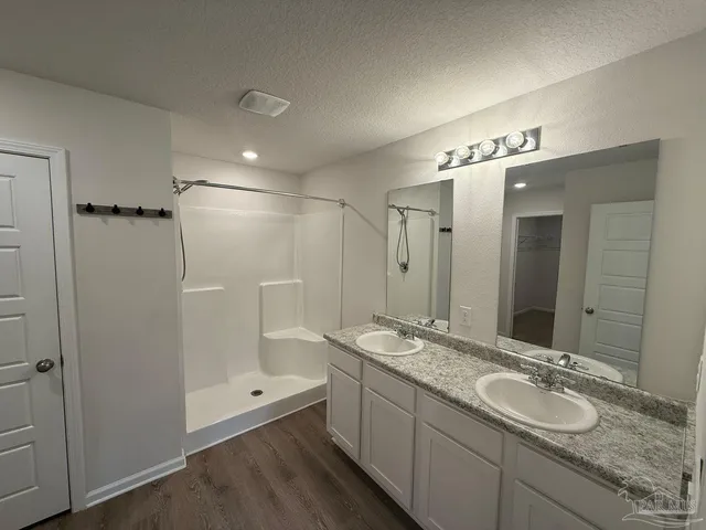 a bathroom with a granite countertop sink mirror and shower