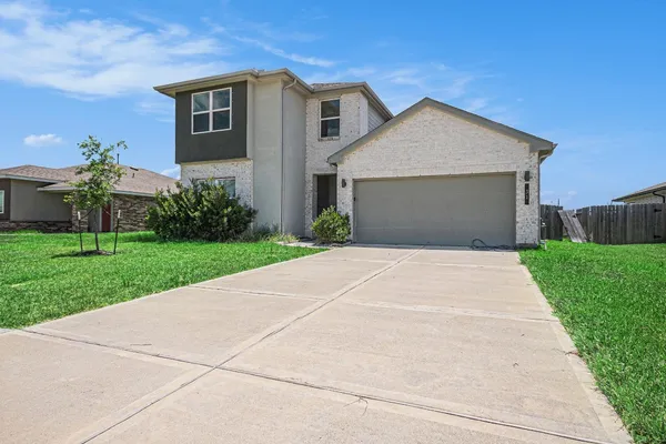 a front view of a house with a yard and garage