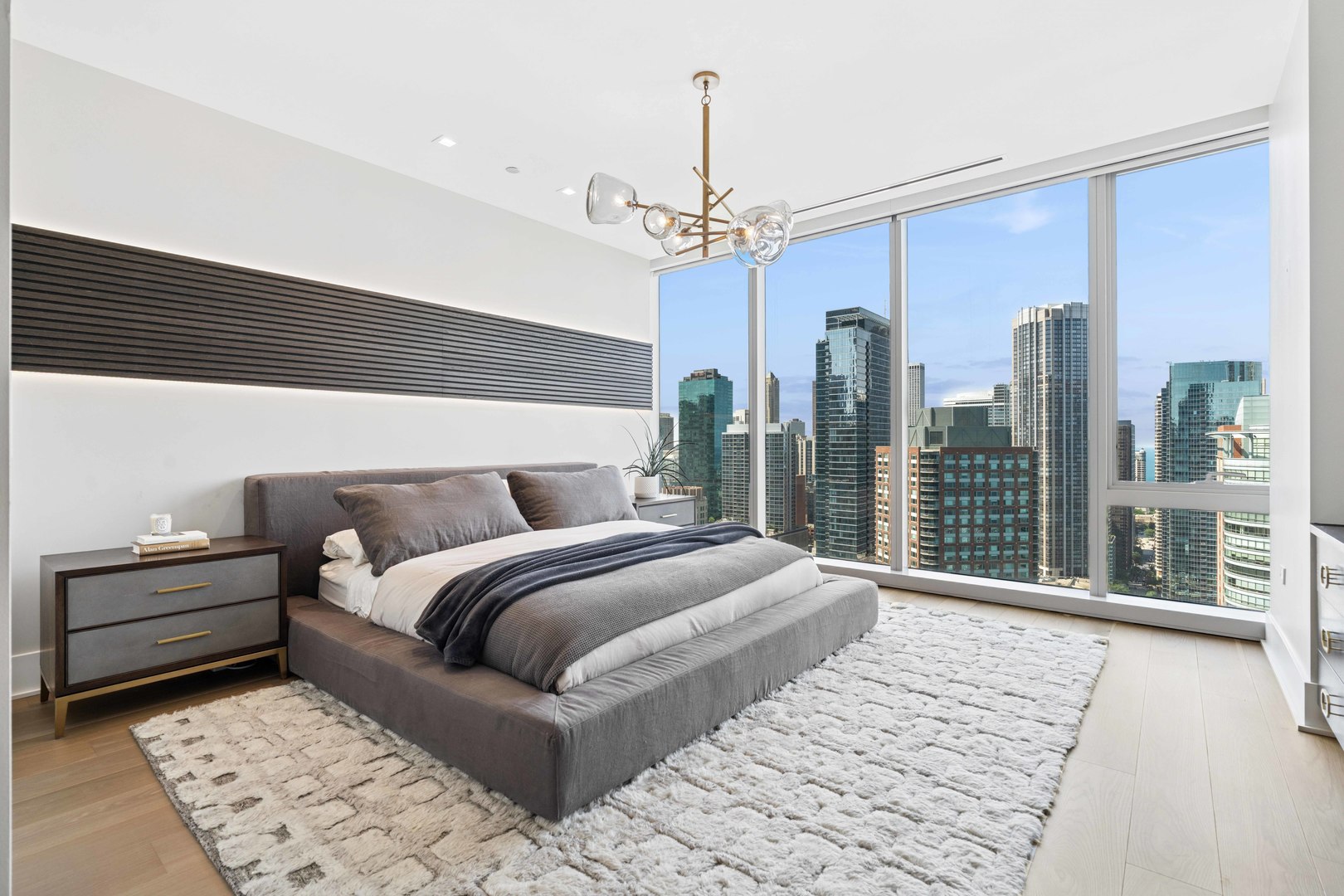 363 East Wacker Drive, Unit 2606 Chicago, IL 60601 - Photo 27 of 68 a bedroom with a large bed and a chandelier
