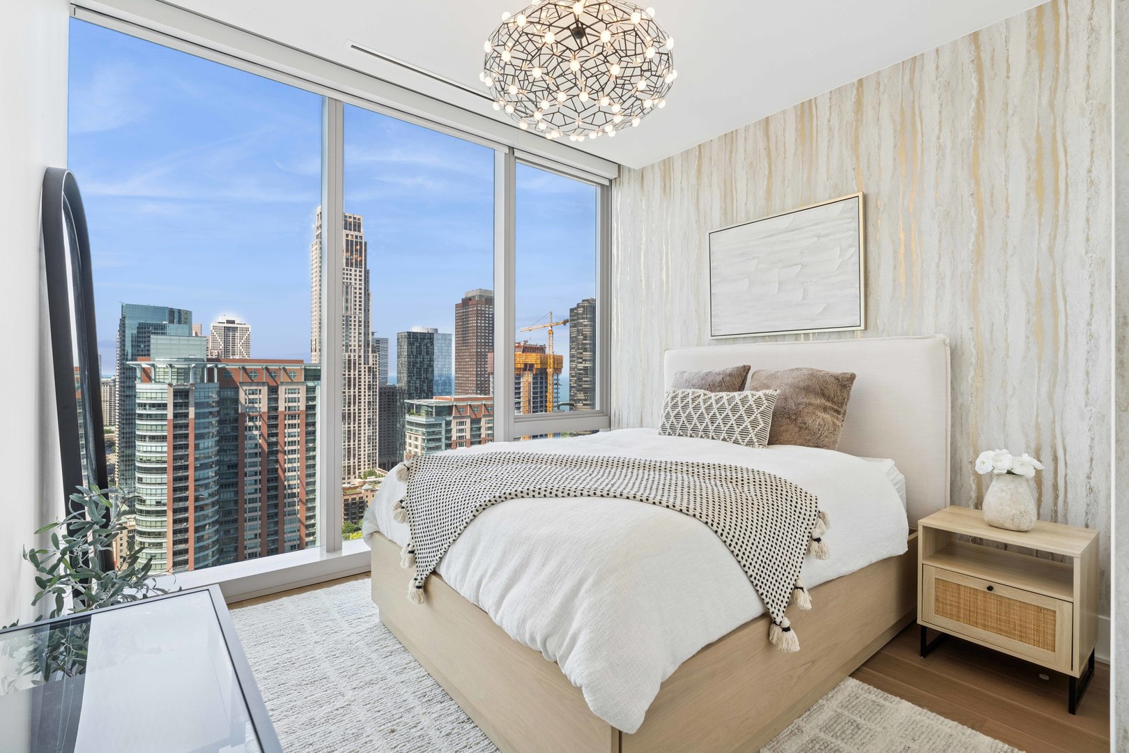 363 East Wacker Drive, Unit 2606 Chicago, IL 60601 - Photo 34 of 68 a spacious bedroom with a large bed and a chandelier